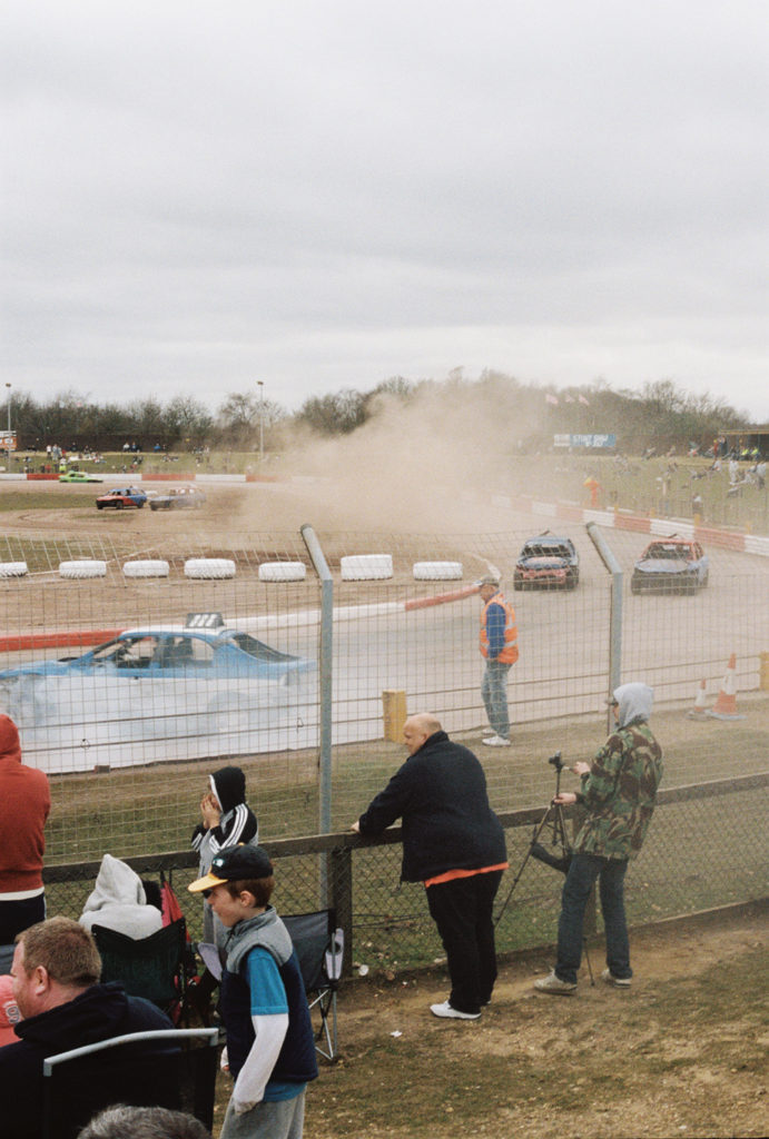 crowd behind fence watching banger racing foxhall stadium